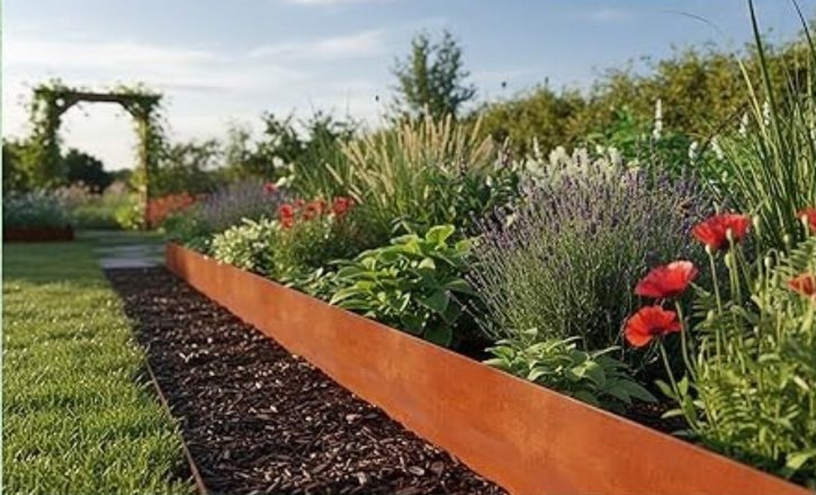Curved corten steel garden edging defining a landscaped bed with ornamental grasses — the American Edging aesthetic